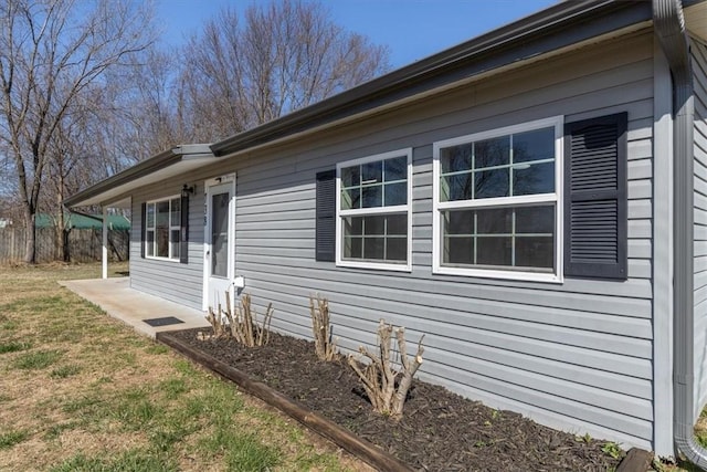 view of home's exterior featuring fence and a lawn