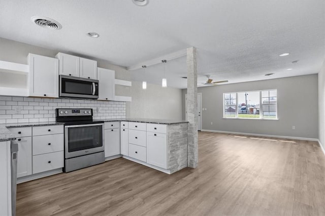 kitchen featuring visible vents, open floor plan, a peninsula, stainless steel appliances, and open shelves