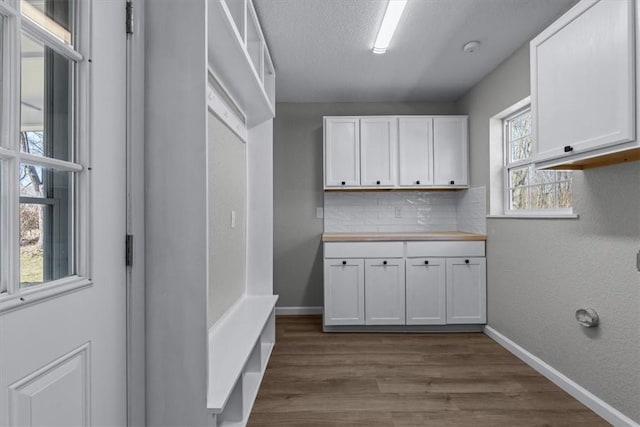 washroom with dark wood-style floors, baseboards, and a textured ceiling