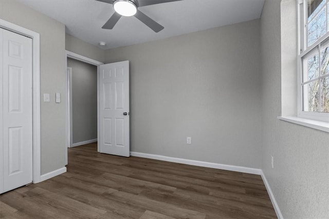 unfurnished bedroom with a ceiling fan, baseboards, and wood finished floors