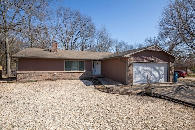 single story home featuring an attached garage, brick siding, driveway, and a chimney