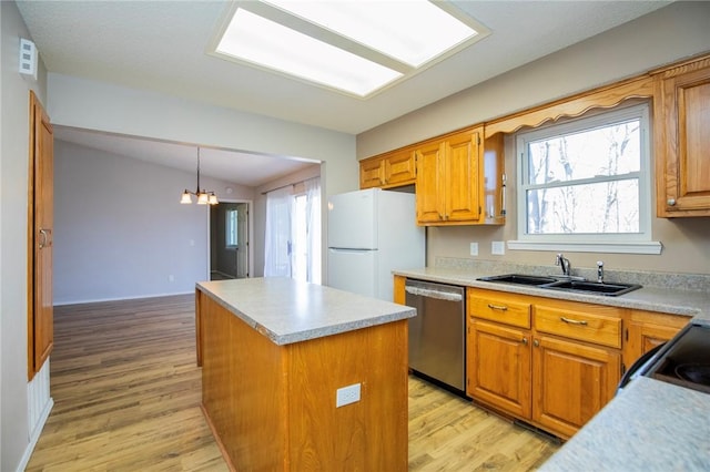 kitchen with a sink, a center island, freestanding refrigerator, light countertops, and dishwasher