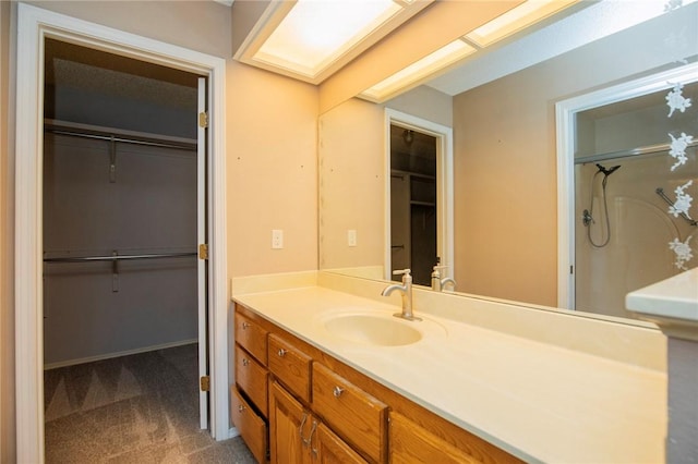 bathroom featuring a skylight, a shower, vanity, and a walk in closet