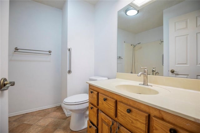 bathroom featuring a shower, toilet, vanity, and baseboards