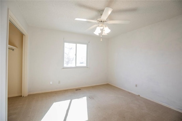 unfurnished bedroom featuring a ceiling fan, a textured ceiling, a closet, carpet flooring, and baseboards