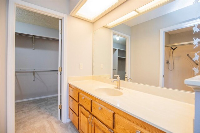 9 Cromer Dr, Bella Vista, AR 72715 - bathroom with a spacious closet, vanity, and a textured ceiling