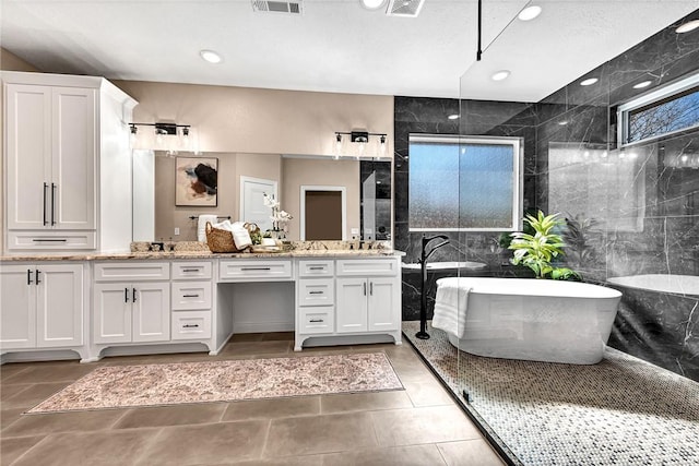 full bath featuring tile patterned flooring, visible vents, double vanity, recessed lighting, and a freestanding tub