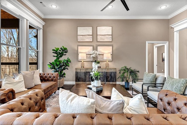 living area featuring visible vents, wood finished floors, baseboards, and ornamental molding