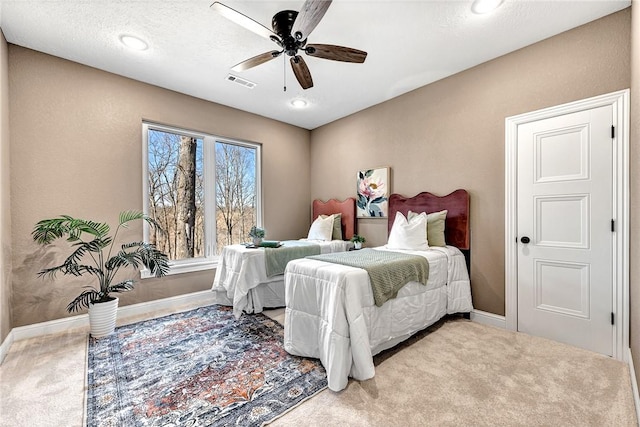 carpeted bedroom featuring visible vents, a textured ceiling, a ceiling fan, and baseboards