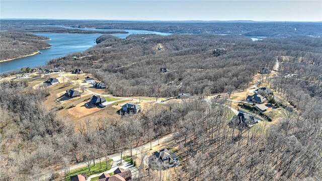 drone / aerial view with a wooded view and a water view