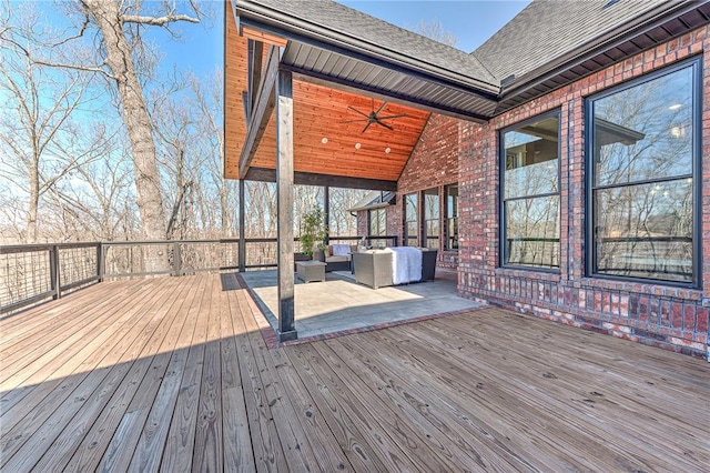 wooden deck with outdoor lounge area and a ceiling fan