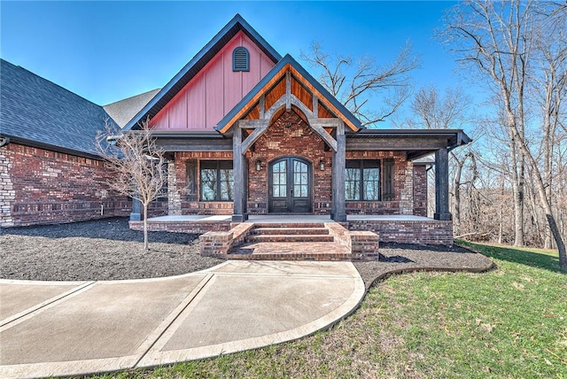 craftsman inspired home with brick siding, french doors, board and batten siding, and roof with shingles