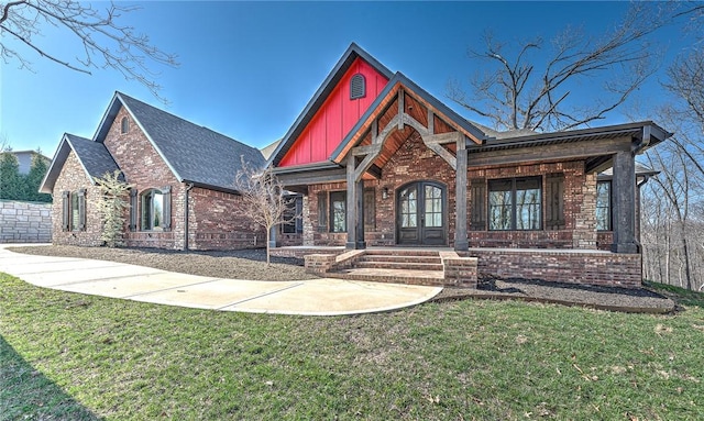 view of front of home featuring french doors, a front yard, and brick siding