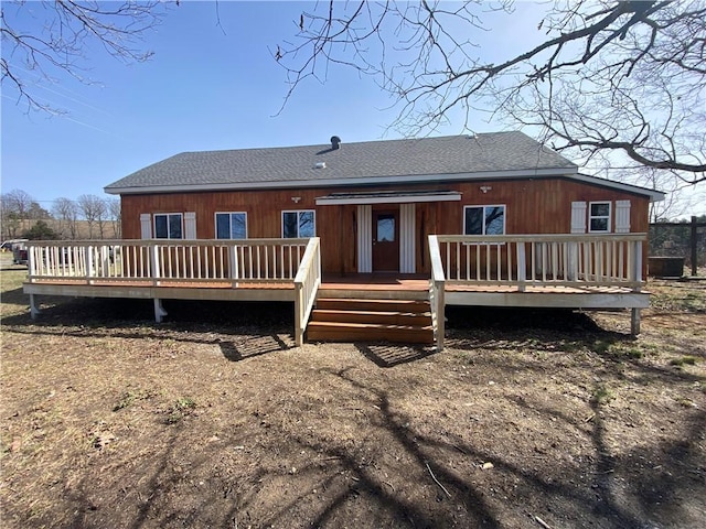 rear view of house featuring roof with shingles and a deck