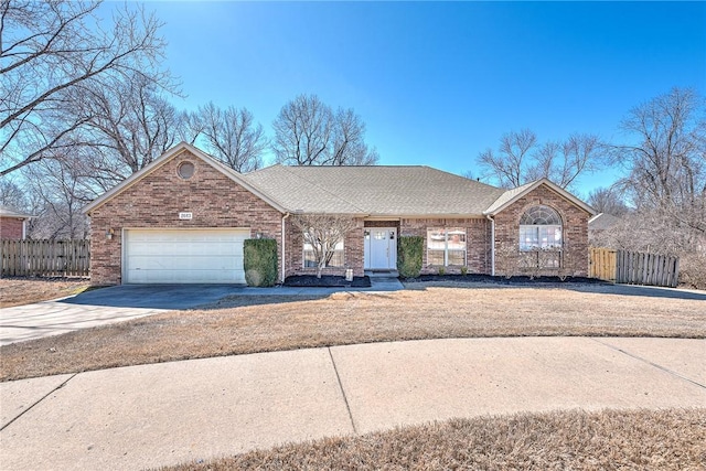 single story home featuring brick siding, driveway, and fence