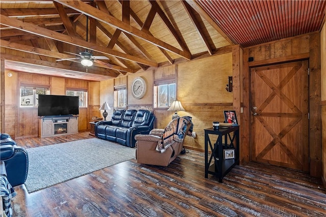 living area featuring lofted ceiling with beams, wood-type flooring, wood walls, wood ceiling, and ceiling fan