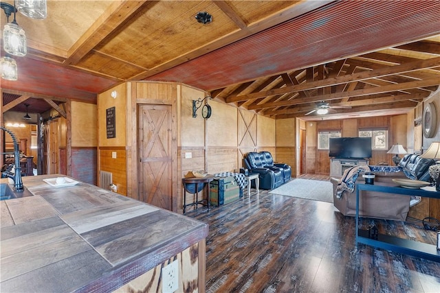 interior space featuring ceiling fan, hardwood / wood-style flooring, wood walls, and wainscoting