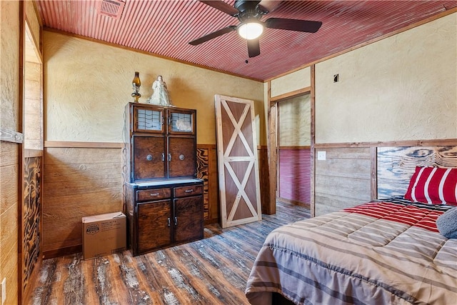 bedroom featuring wood finished floors, wood ceiling, wood walls, wainscoting, and a textured wall