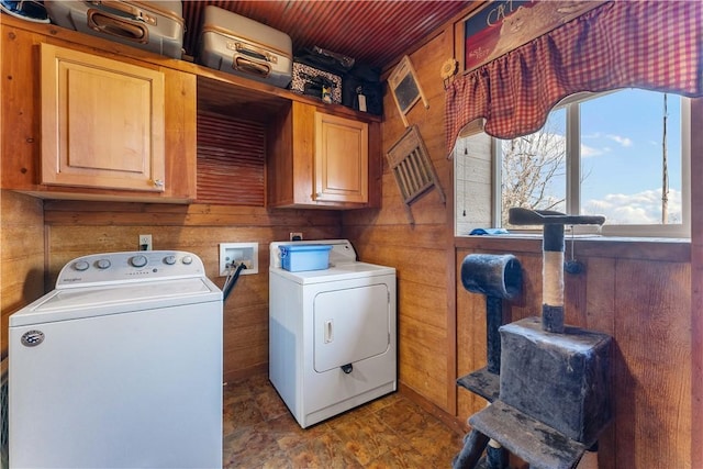 washroom featuring washer and clothes dryer, wood walls, wood ceiling, and cabinet space