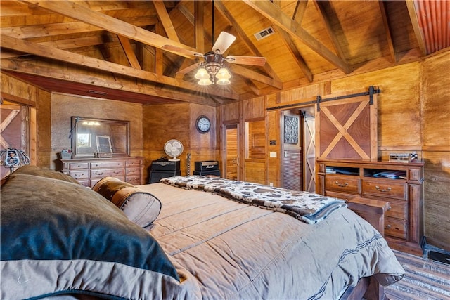 bedroom with visible vents, lofted ceiling with beams, a barn door, wooden walls, and wood ceiling