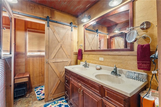 full bathroom with double vanity, wooden walls, wood ceiling, and a sink