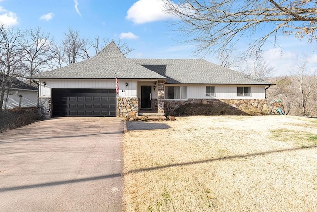 ranch-style house featuring concrete driveway, an attached garage, stone siding, and a shingled roof