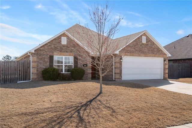 view of front of house with brick siding, concrete driveway, and fence