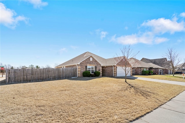 single story home featuring a front lawn, fence, concrete driveway, an attached garage, and brick siding