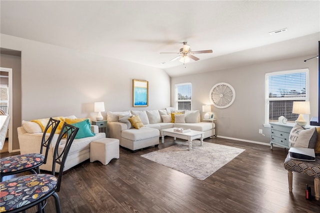 living area featuring dark wood-style floors, baseboards, visible vents, ceiling fan, and vaulted ceiling