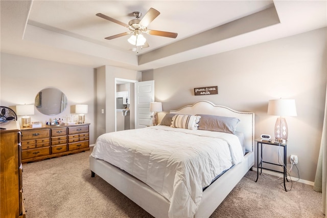 carpeted bedroom with ceiling fan, a raised ceiling, and baseboards