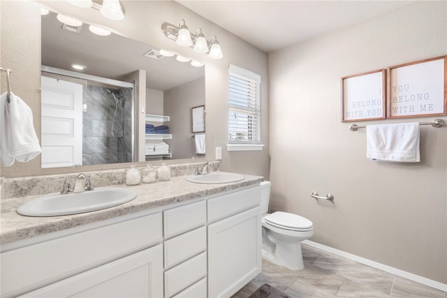 bathroom featuring double vanity, a stall shower, toilet, and a sink