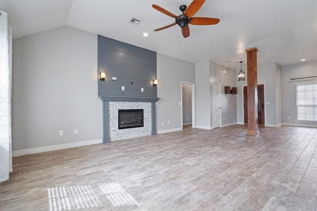 unfurnished living room with a ceiling fan, visible vents, baseboards, a fireplace, and vaulted ceiling