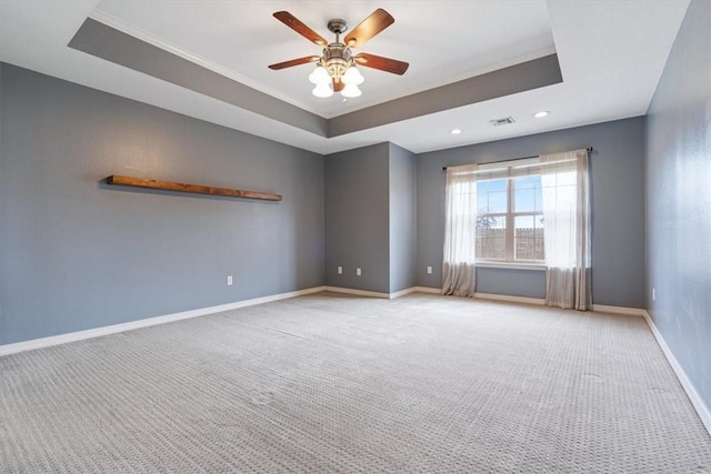 empty room featuring light carpet, crown molding, visible vents, and a raised ceiling