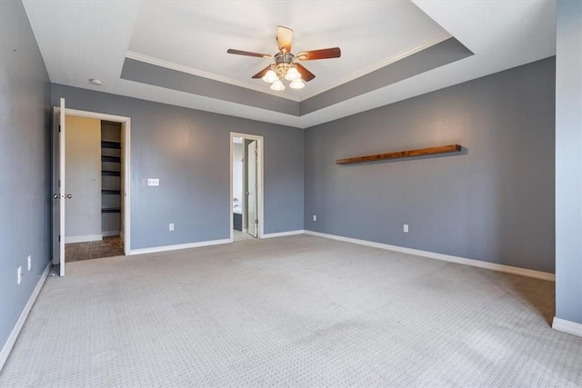 unfurnished bedroom with carpet floors, ornamental molding, and a tray ceiling