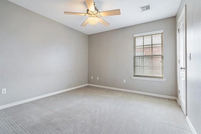 spare room with visible vents, light carpet, baseboards, and a ceiling fan