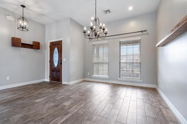 foyer entrance with wood finished floors, visible vents, baseboards, and an inviting chandelier