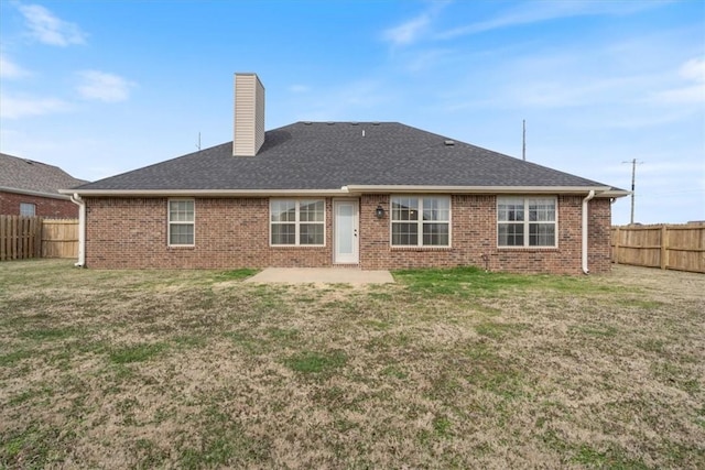 back of house featuring a patio area, a fenced backyard, a chimney, and brick siding