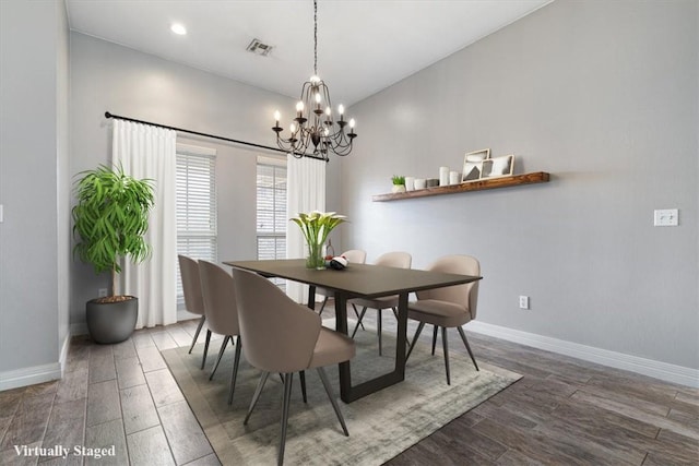 dining space featuring visible vents, baseboards, wood finished floors, and a notable chandelier