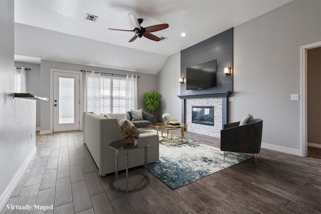 living room featuring baseboards, a glass covered fireplace, wood finished floors, and visible vents
