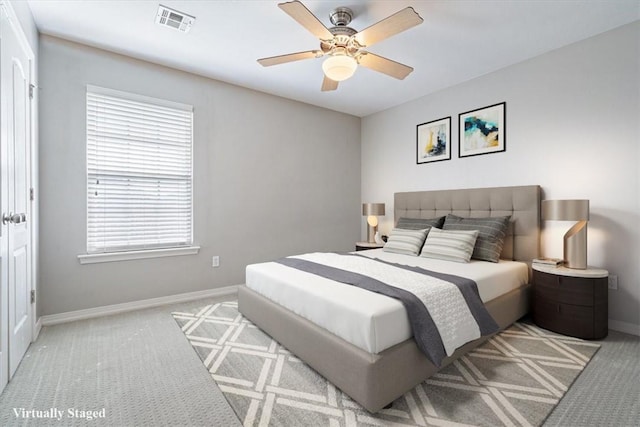 bedroom featuring light carpet, multiple windows, visible vents, and baseboards