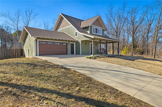 view of front of home featuring a porch, concrete driveway, fence, and a garage