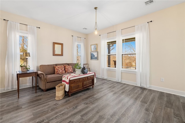 living room featuring visible vents, baseboards, and dark wood-style flooring