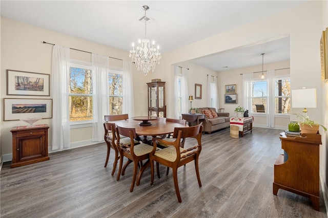 dining space with visible vents, baseboards, an inviting chandelier, and wood finished floors