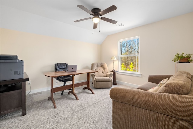 carpeted home office with a ceiling fan, vaulted ceiling, baseboards, and visible vents