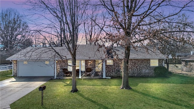 ranch-style home with driveway, roof with shingles, a front lawn, a garage, and brick siding