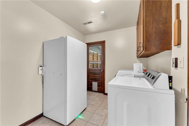 laundry area with washer and clothes dryer, visible vents, cabinet space, and light tile patterned flooring