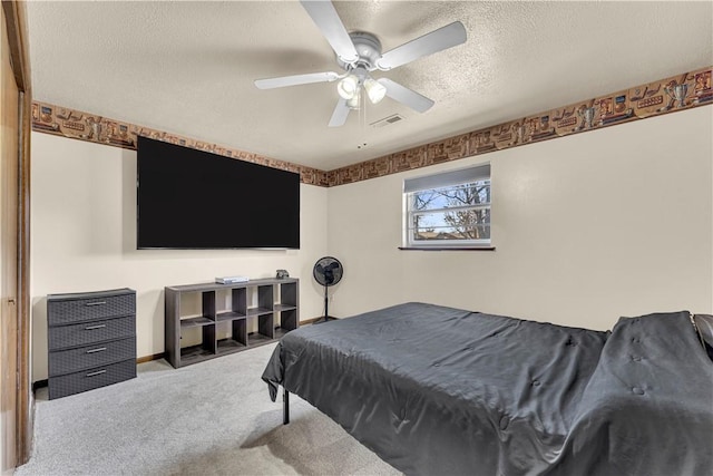 carpeted bedroom featuring baseboards, visible vents, a textured ceiling, and a ceiling fan