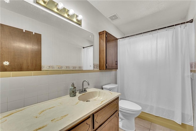 full bathroom featuring vanity, curtained shower, tile patterned floors, toilet, and tile walls