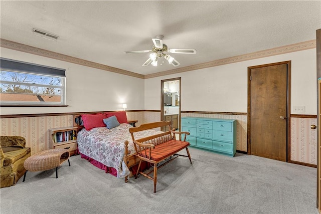 bedroom featuring a wainscoted wall, wallpapered walls, visible vents, and carpet floors