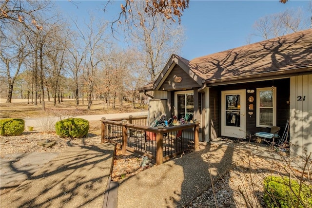 view of exterior entry with a shingled roof